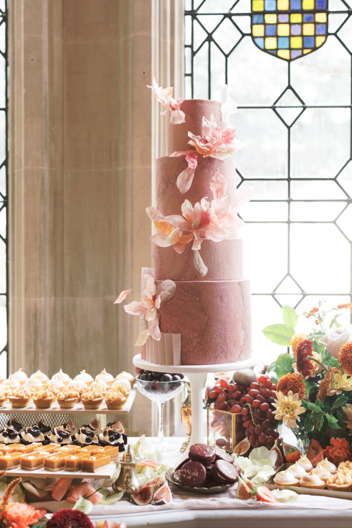 Elegant wedding cake with floral decorations and desserts