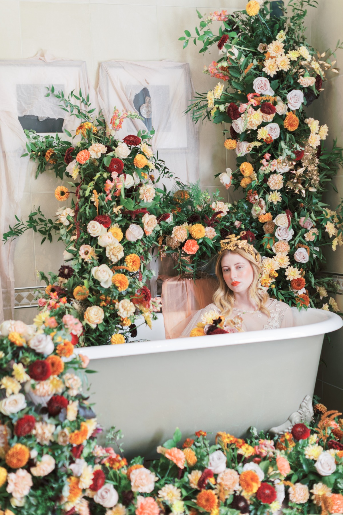 Woman in floral bath tub surrounded by colorful flowers