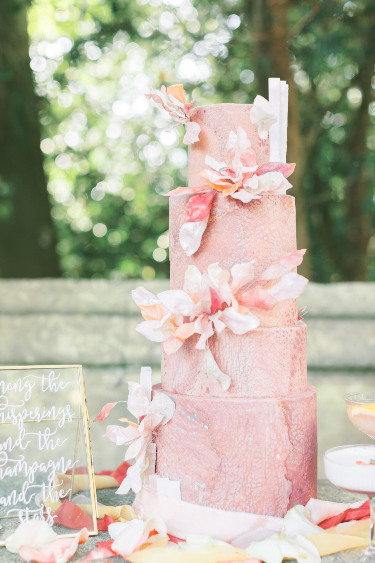 Elegant blush pink wedding cake decorated with floral accents