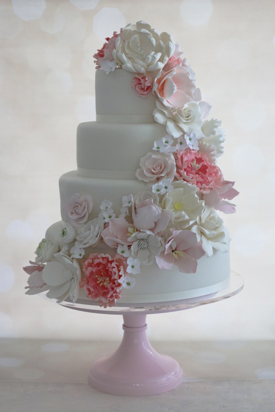 Elegant three-tiered wedding cake with cascading sugar flowers