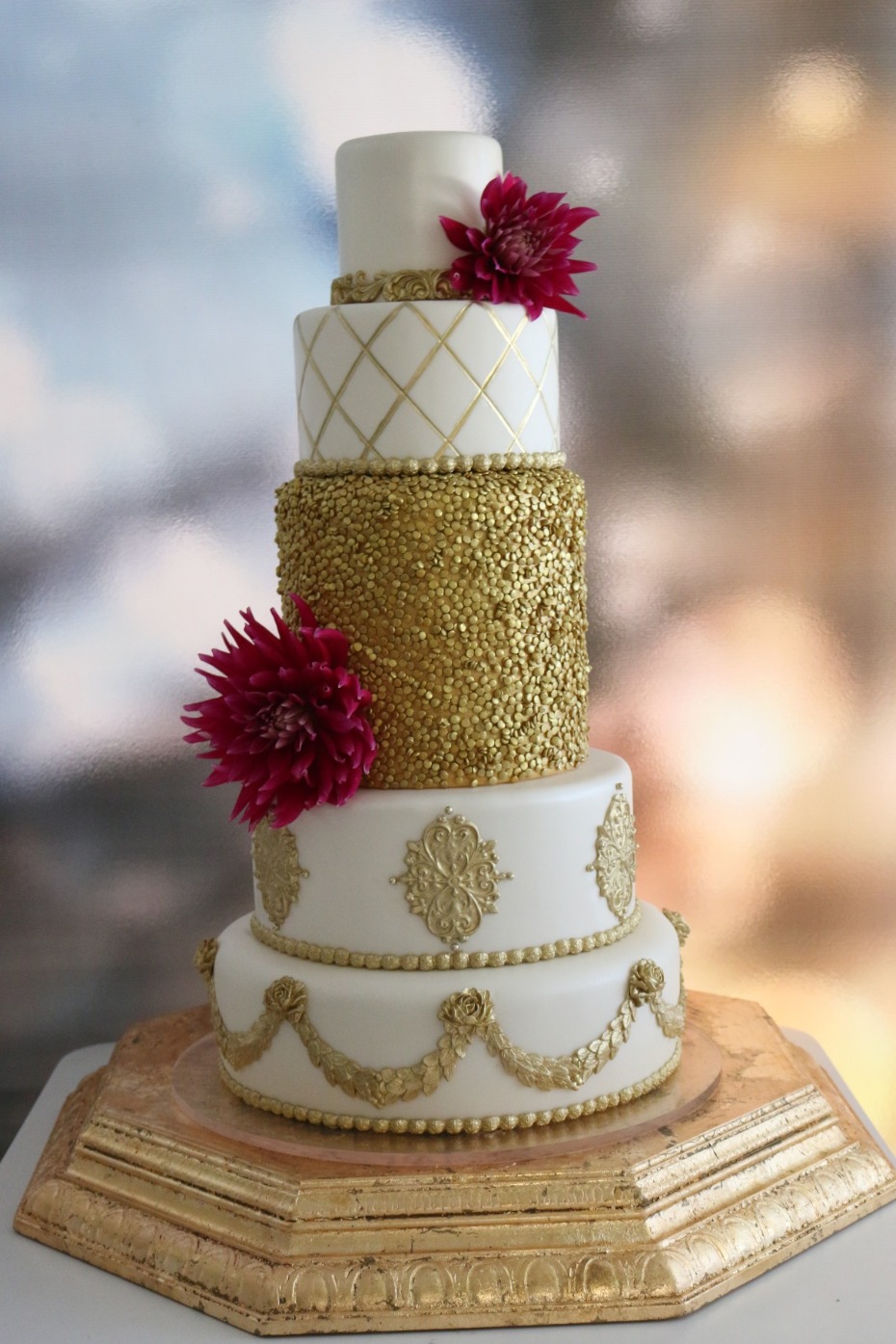 Elegant golden wedding cake with red flowers, a sweet celebration