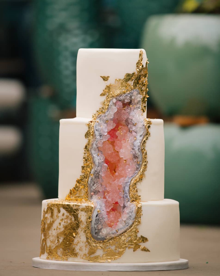 Elegant three-tiered geode wedding cake with gold leaf accents