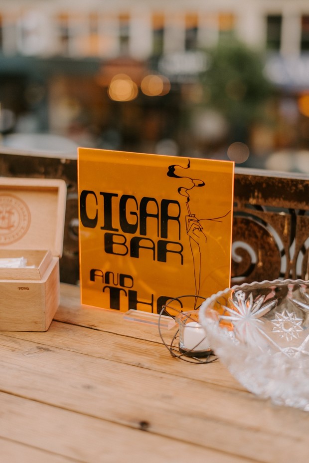 Cigar Bar sign on a wooden table with an open cigar box
