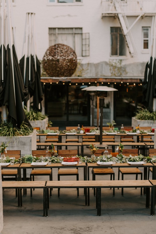 Outdoor wedding reception setup with decorated tables and benches