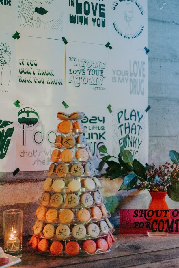 Macaron tower with a party backdrop, candles and a floral decor