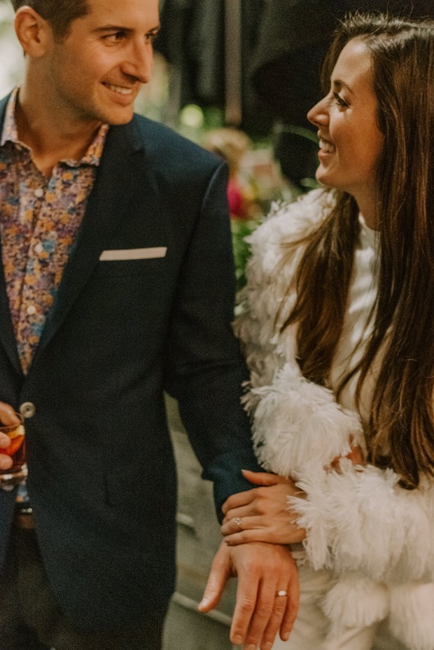 Smiling couple holding hands with a wedding ring