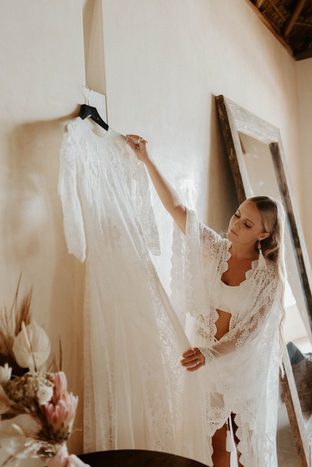 Woman admires her lace wedding gown before ceremony