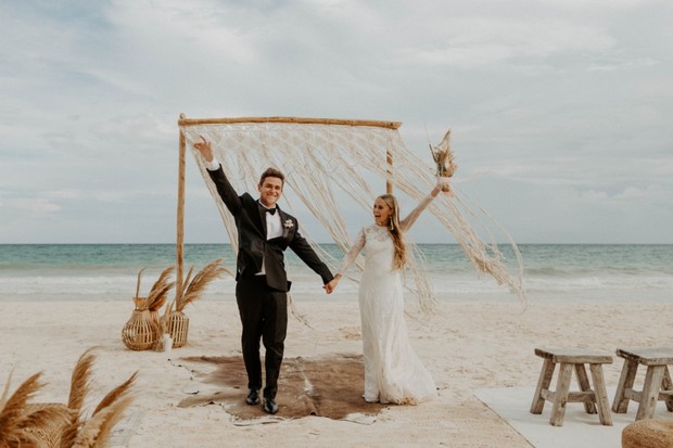 Beach wedding joyfully celebrating happy bride and groom