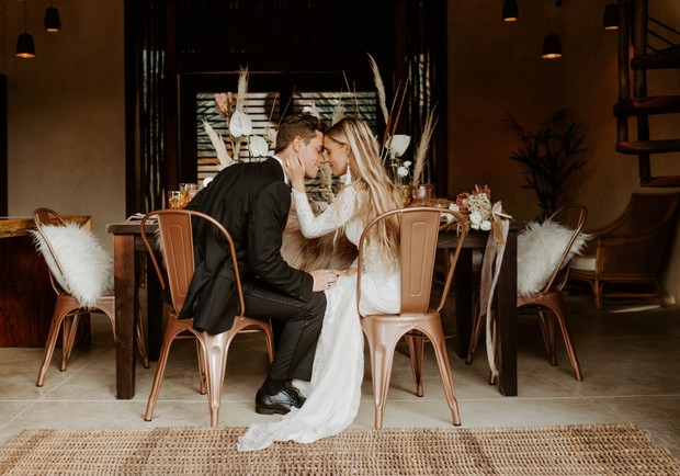 Bride and groom share a tender moment at wedding table
