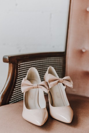 Elegant pink heels with bow detail on velvet chair