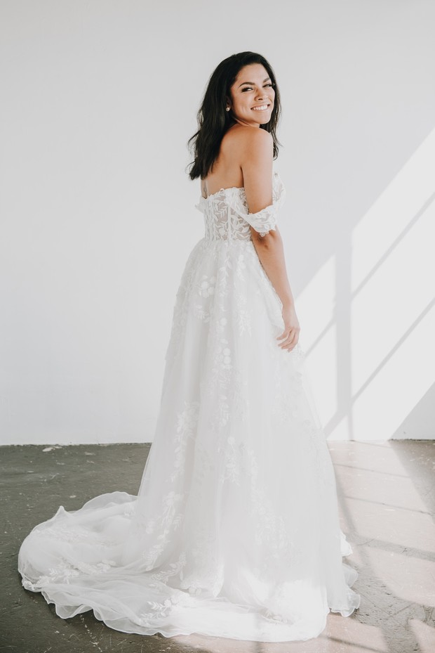 Smiling bride in a beautiful white wedding dress, looking over her shoulder