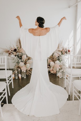 Bride in elegant white wedding dress with open arms