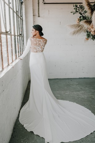 Bride in long white wedding dress with lace back detail