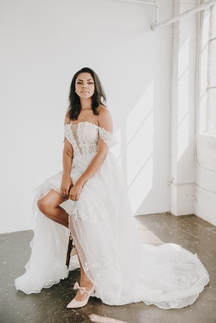 Elegant bride in a stunning off-the-shoulder wedding dress posing gracefully