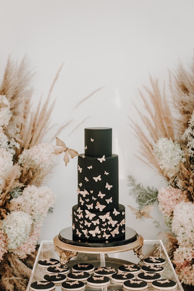 Elegant black butterfly wedding cake with matching cookies