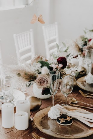 Elegant wedding table decor with flowers, candles, and a butterfly