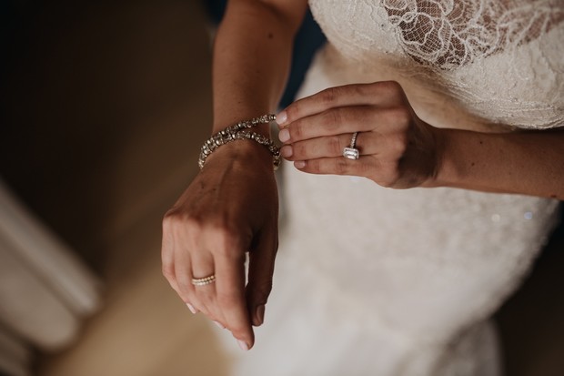 Bride fastening her delicate bracelet on wedding day