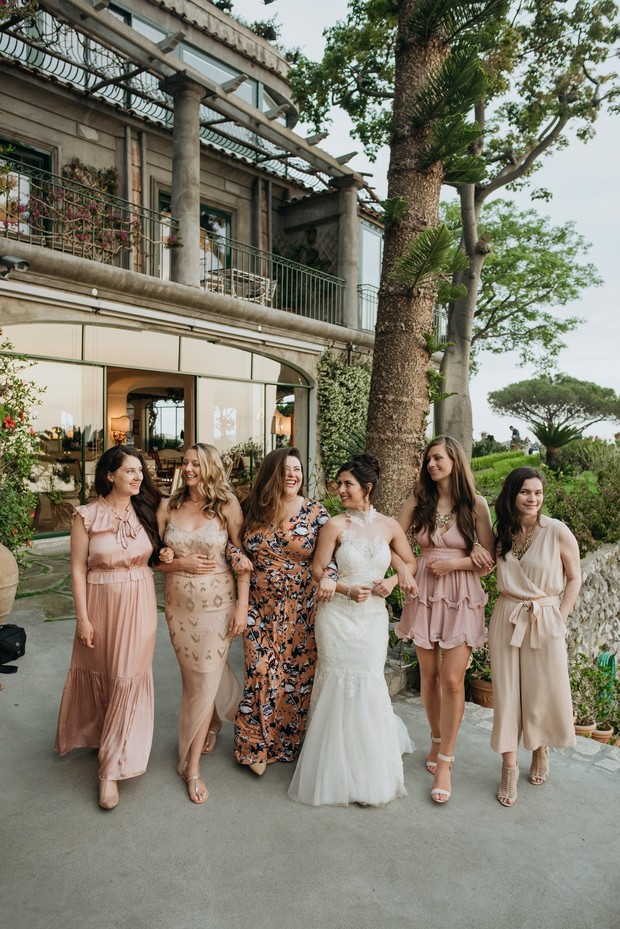 Bride and bridesmaids stroll outside Italian villa