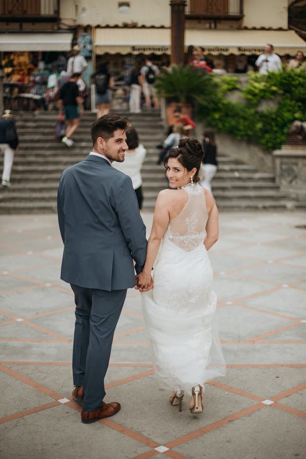Newlyweds holding hands on their wedding day in Italy
