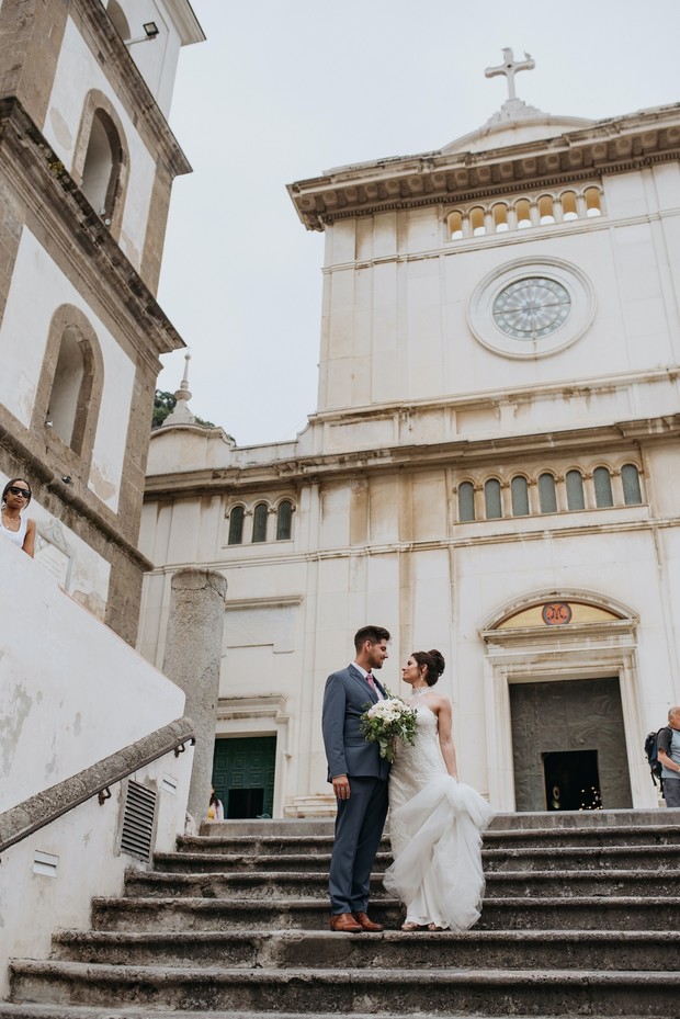 Bride and groom on steps of Italian church wedding