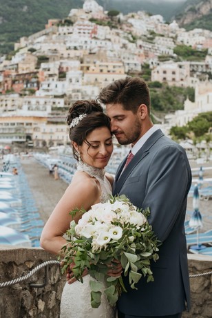 Newlyweds embrace during their destination wedding, with a sea view