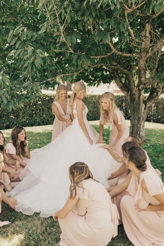 bridesmaids in blush and bride ready for her wedding
