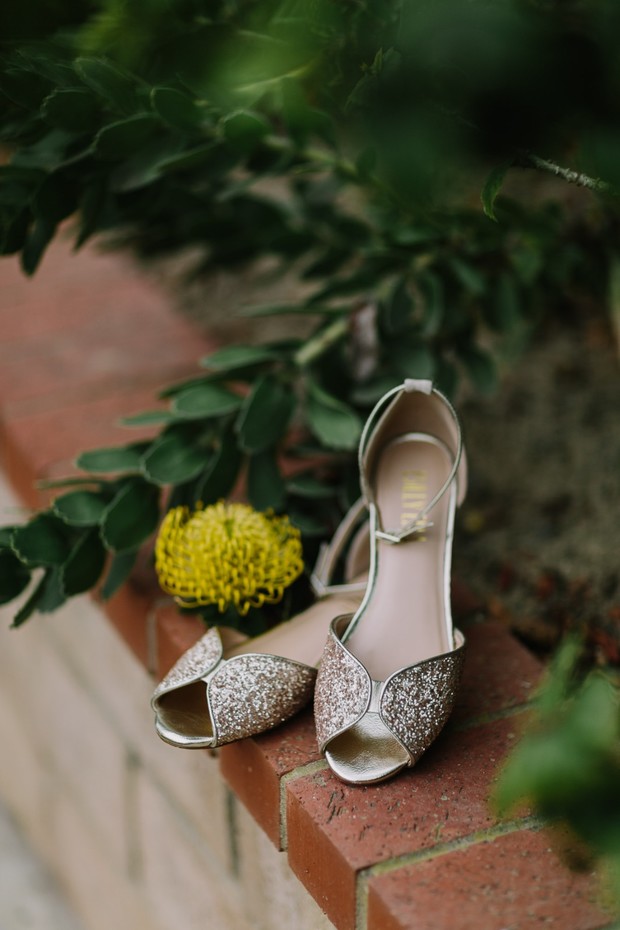 Sparkly gold wedding shoes with yellow flower accent