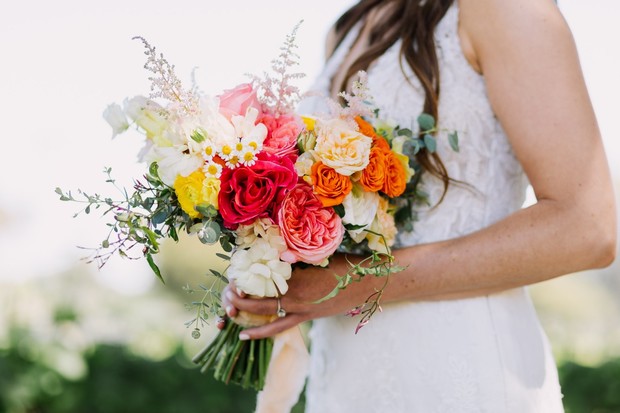 Bride holding a vibrant colorful bouquet of flowers