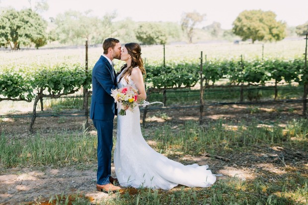 Bride and groom kissing in a vineyard wedding photo