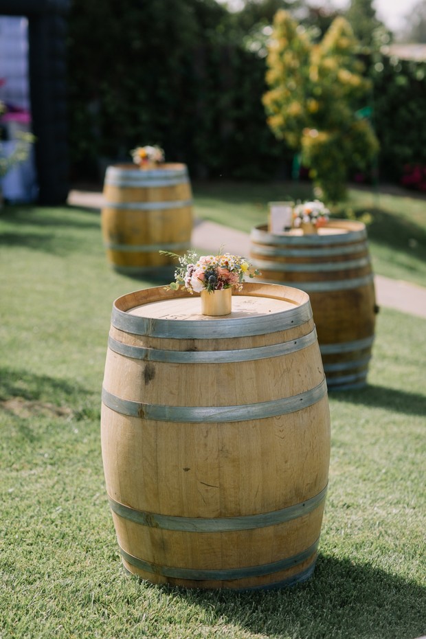 Wine barrels topped with flowers on green grass lawn