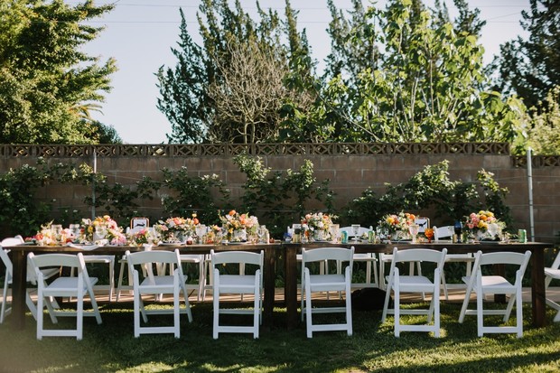 Outdoor wedding reception table setting flowers chairs