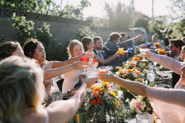 Wedding guests toasting at an outdoor reception table