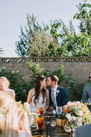 Bride and groom kissing at their outdoor wedding reception