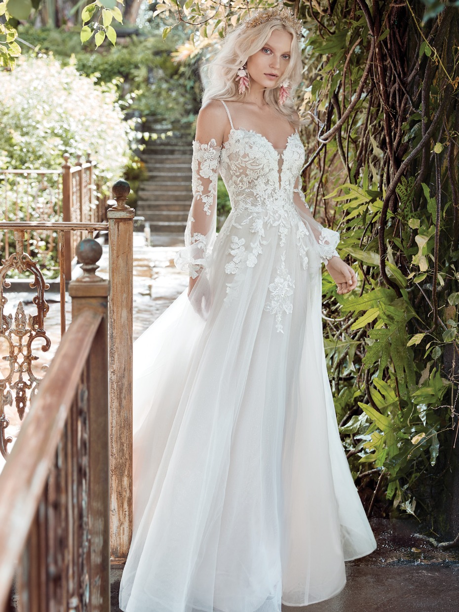 Bride in lace gown with sheer sleeves in a garden setting