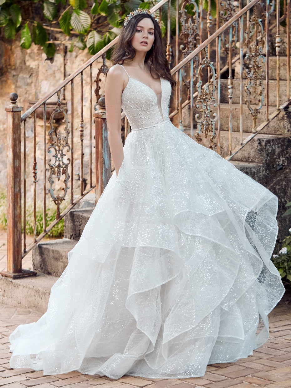 Elegant bride in a layered white wedding gown with sparkling details