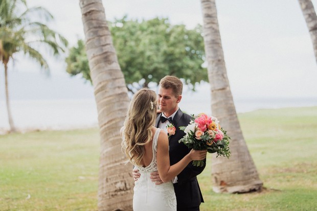 Bride and groom embrace at a tropical beach wedding