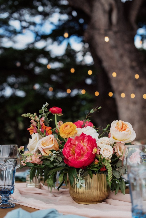 Colorful flower arrangement in golden vase outdoors