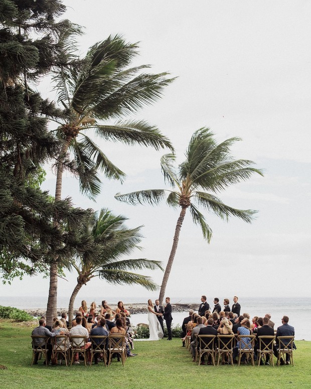 Outdoor wedding ceremony under palm trees by the ocean
