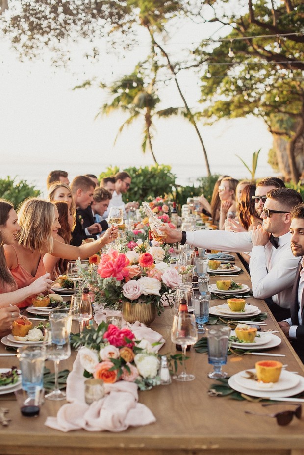 Wedding reception dinner at a long table with flowers