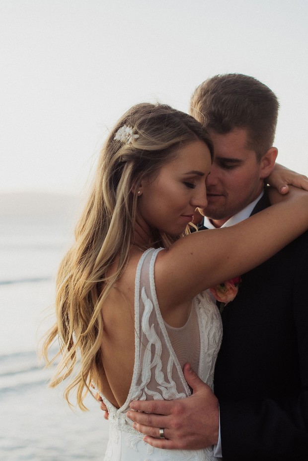 Bride and groom embrace at their beach wedding ceremony