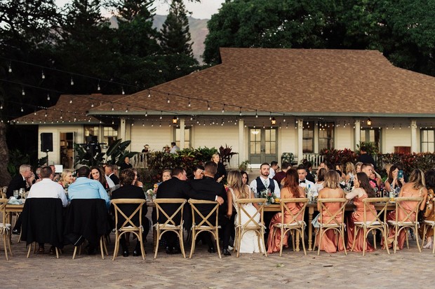 Outdoor wedding reception with guests at long tables