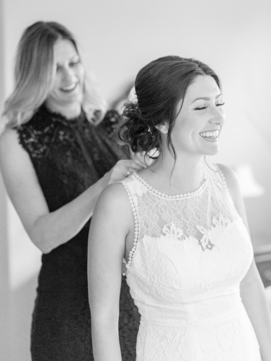 Bride smiling while getting ready, wearing a beautiful wedding dress