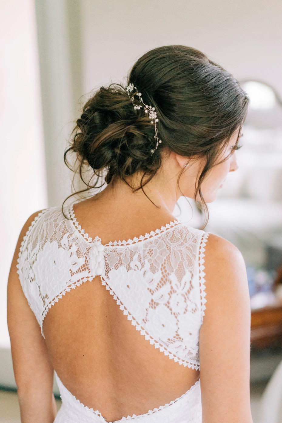 Bride with updo hairstyle and lace wedding dress back