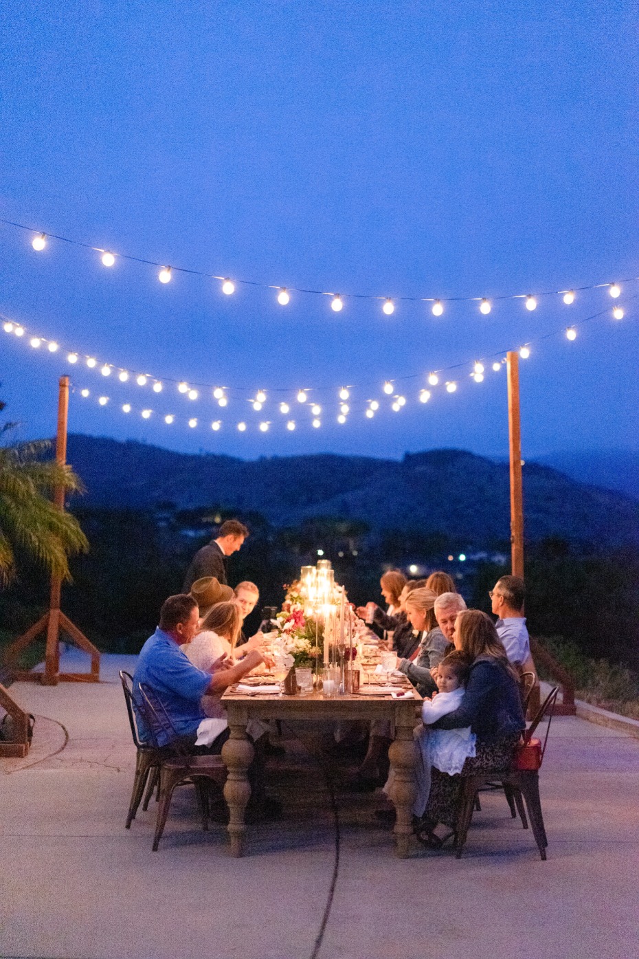 Outdoor dinner party with string lights and beautiful scenery