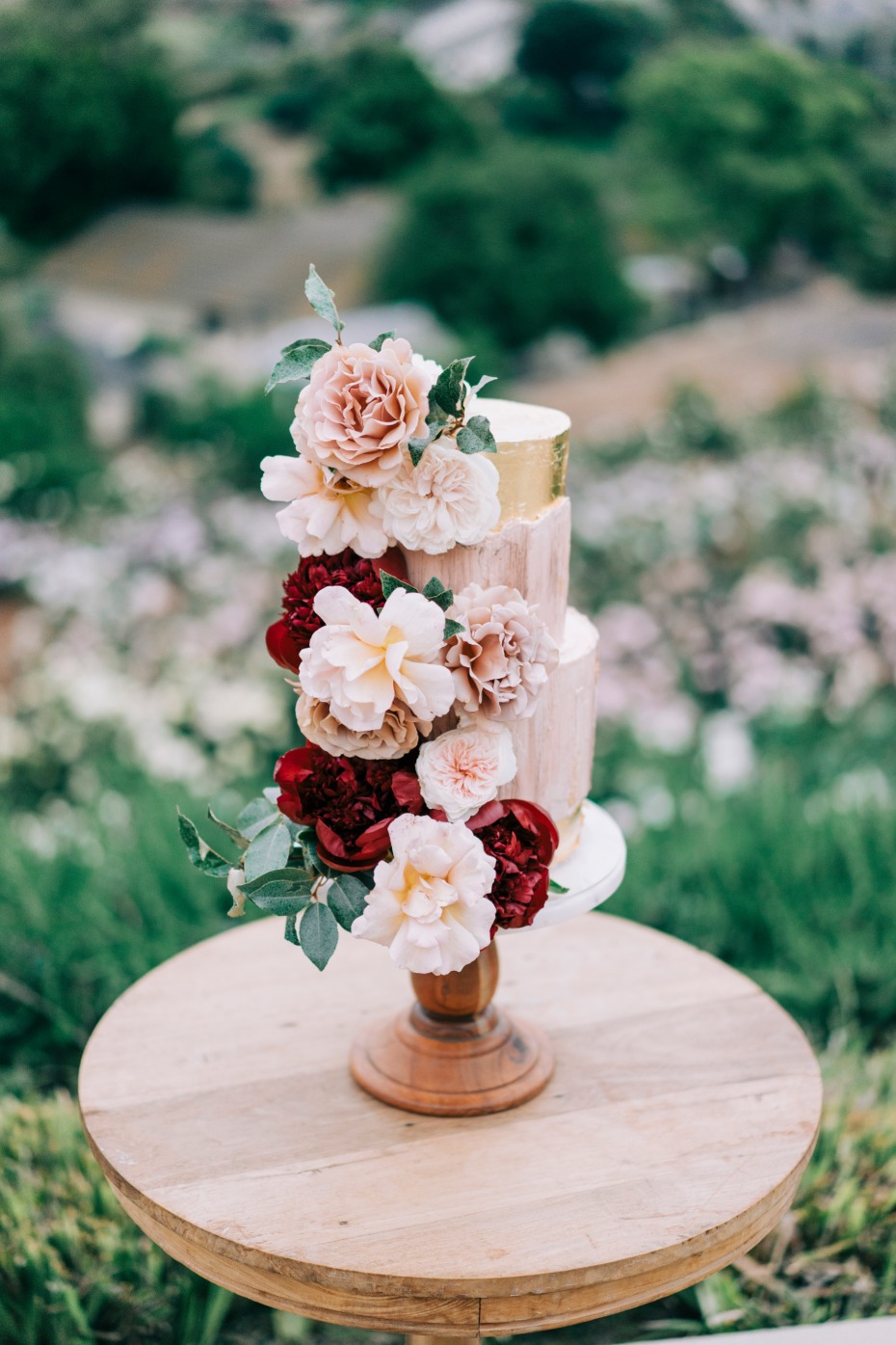 Elegant wedding cake decorated with beautiful flowers outdoors