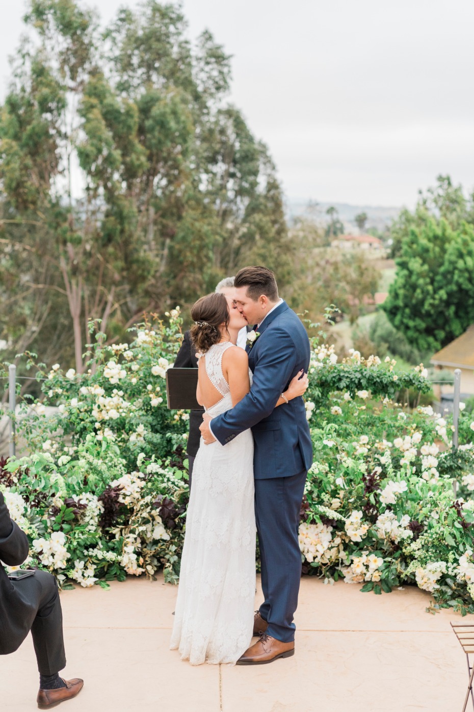 Bride and groom share first kiss at outdoor wedding