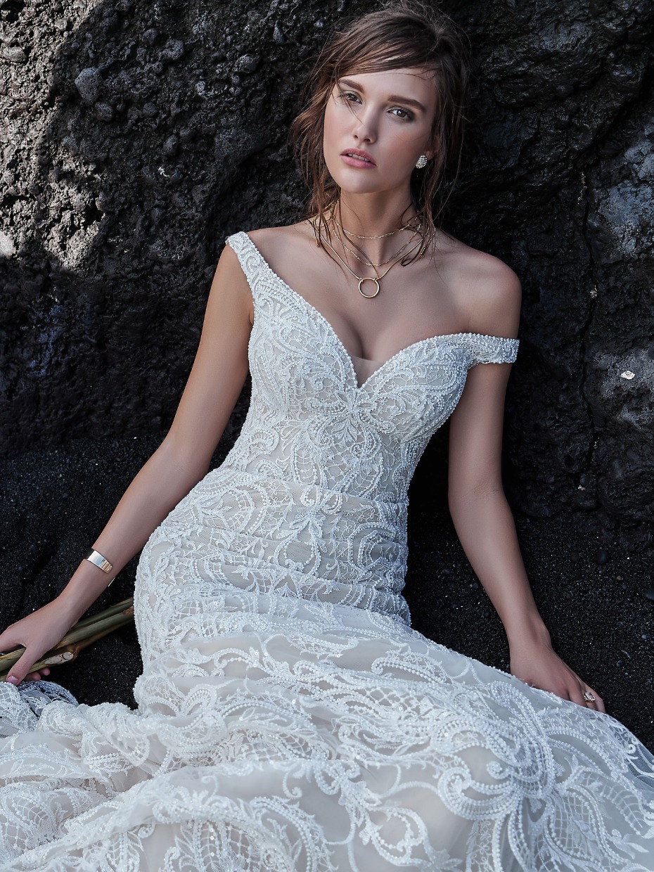 Beautiful bride posing in intricate lace wedding dress outdoors