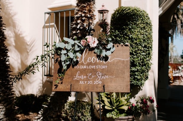 wooden welcome wedding sign with eucalyptus and roses