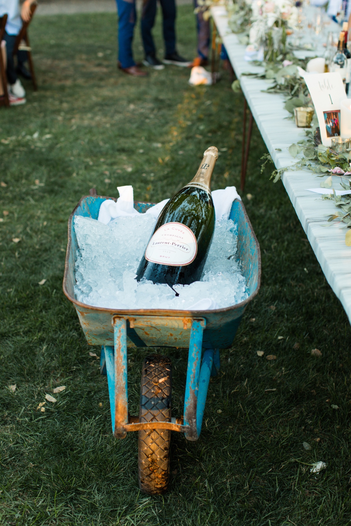 giant bottle of champange in a wheel barrow