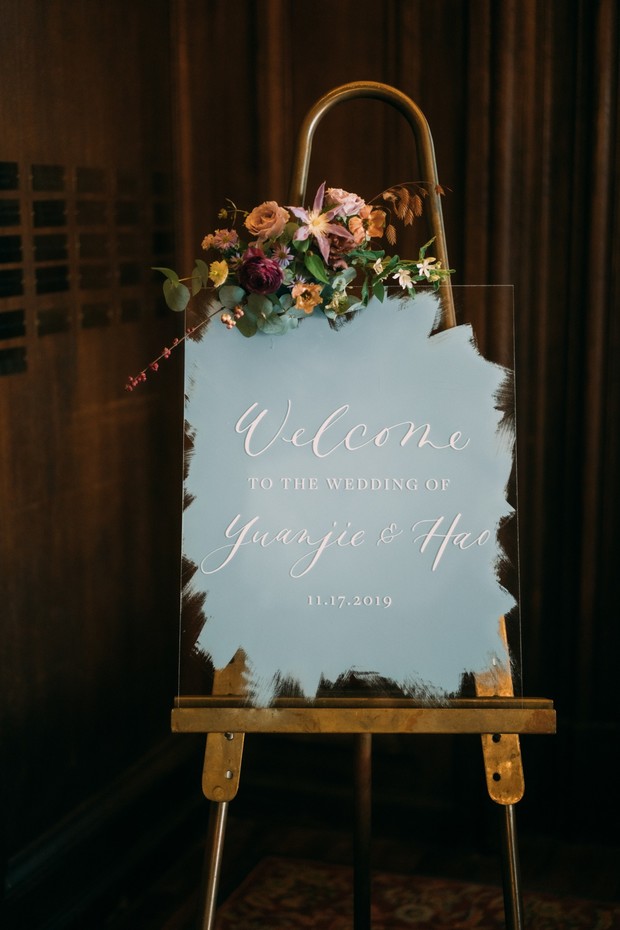 acrylic welcome wedding sign on brass sign with florals
